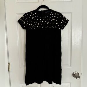 Black mini sweater dress with pearl accents. Zara
